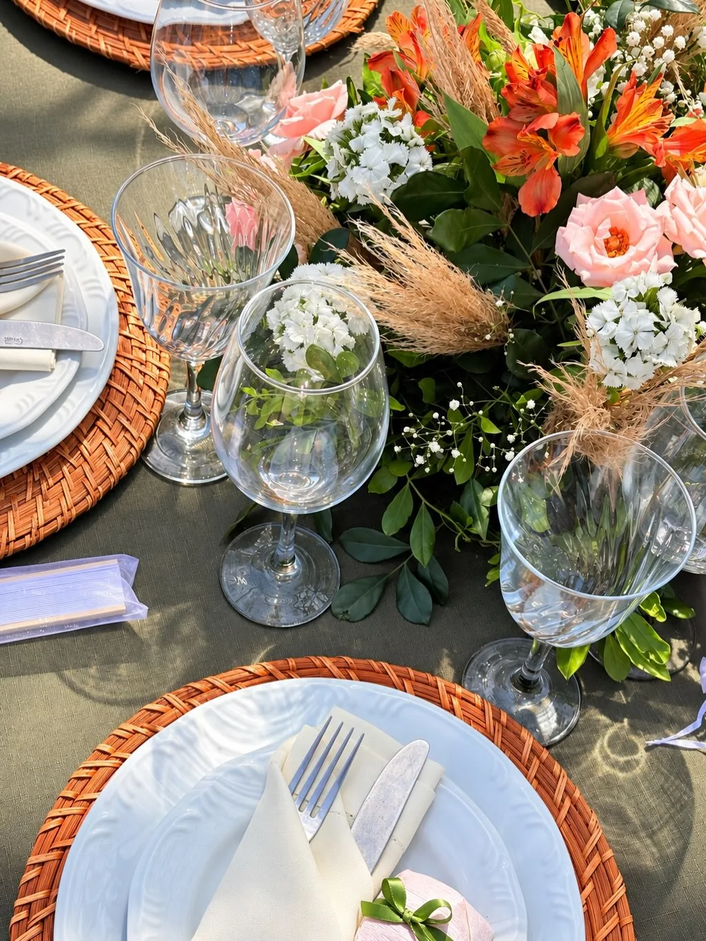 Mesa posta com flores, taças e sousplat de palha